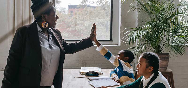 Teacher high fiving students